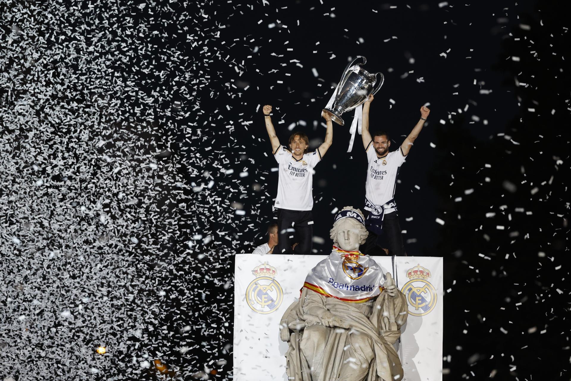 Los capitanes del Real Madrid Nacho Fernández y Luka Modrić (i) levantan el trofeo este domingo a la Plaza de Cibeles, donde el equipo celebra con la afición su victoria en la final de la Liga de Campeones. (EFE)