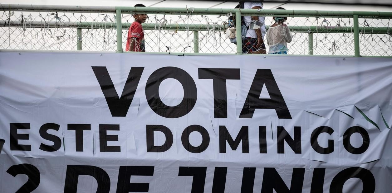 Un cartel en un puente en Xochimilco, México, llama a votar, en el final de una campaña teñida de sangre. (Foto: AFP)