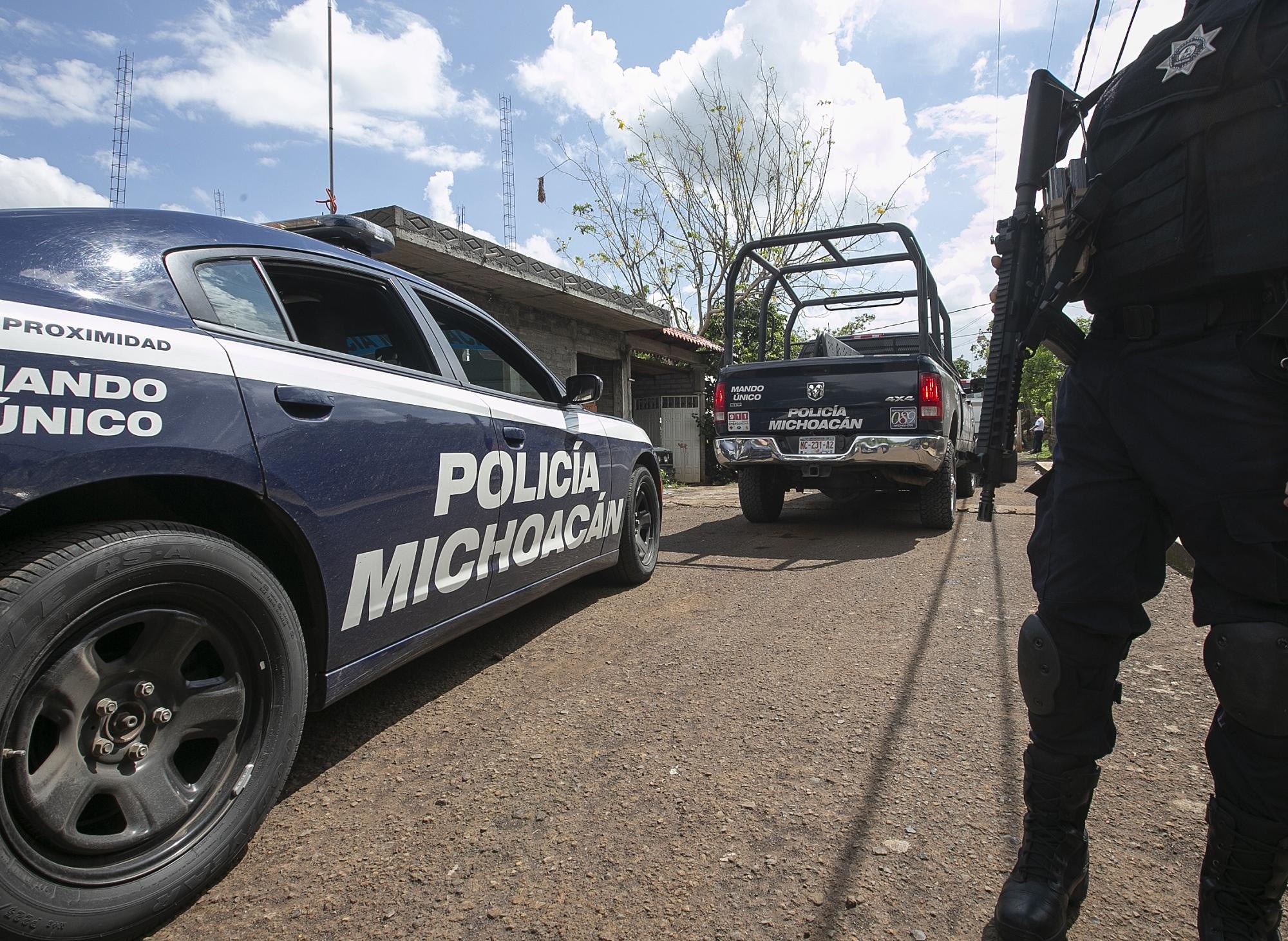 Imagen de archivo de policías estatales que custodian el lugar donde fue asesinado un candidato, en Michoacán, (Ivan Villanueva / EFE)