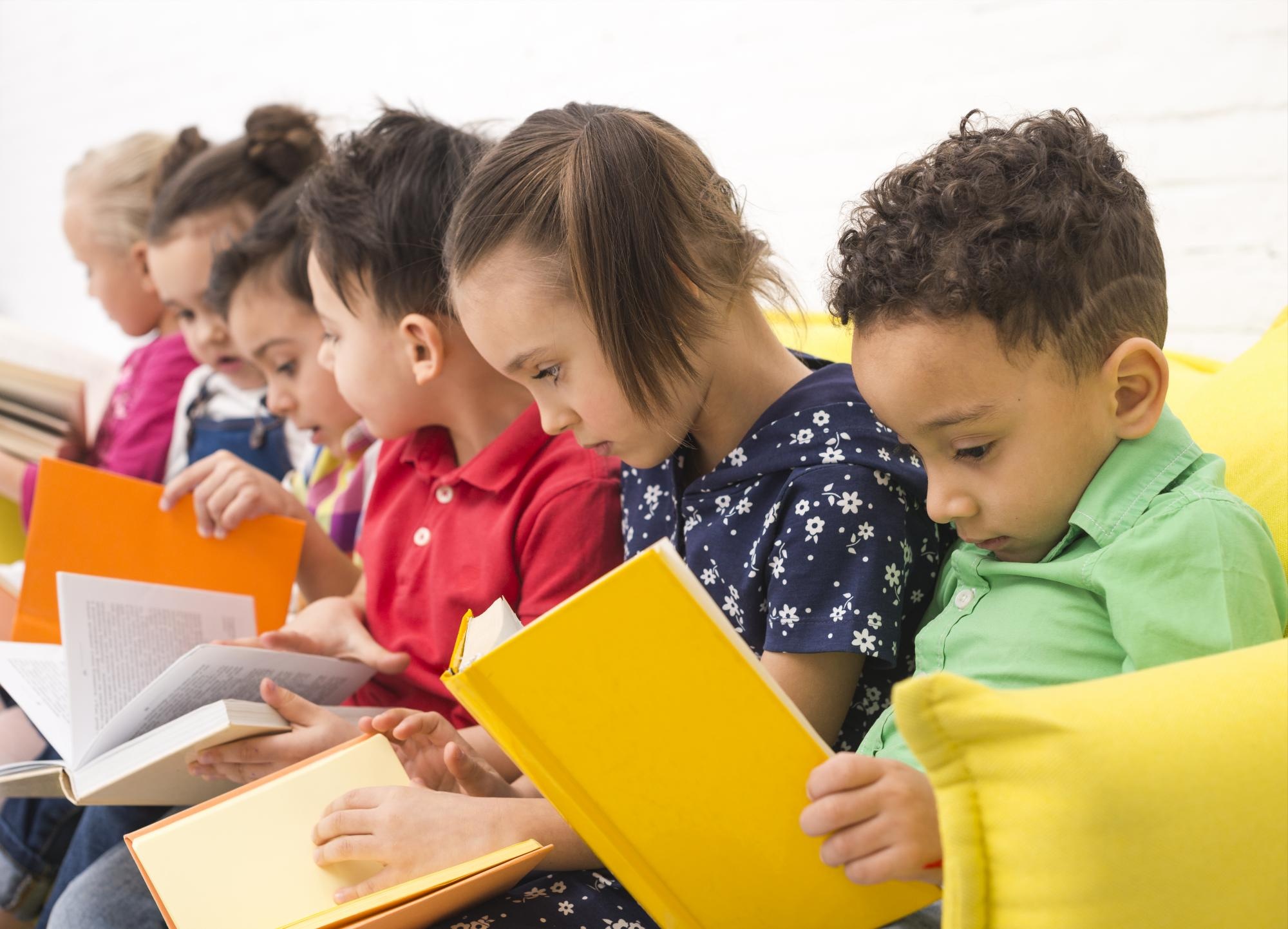Grupo de niños leyendo libros. (Freepik)