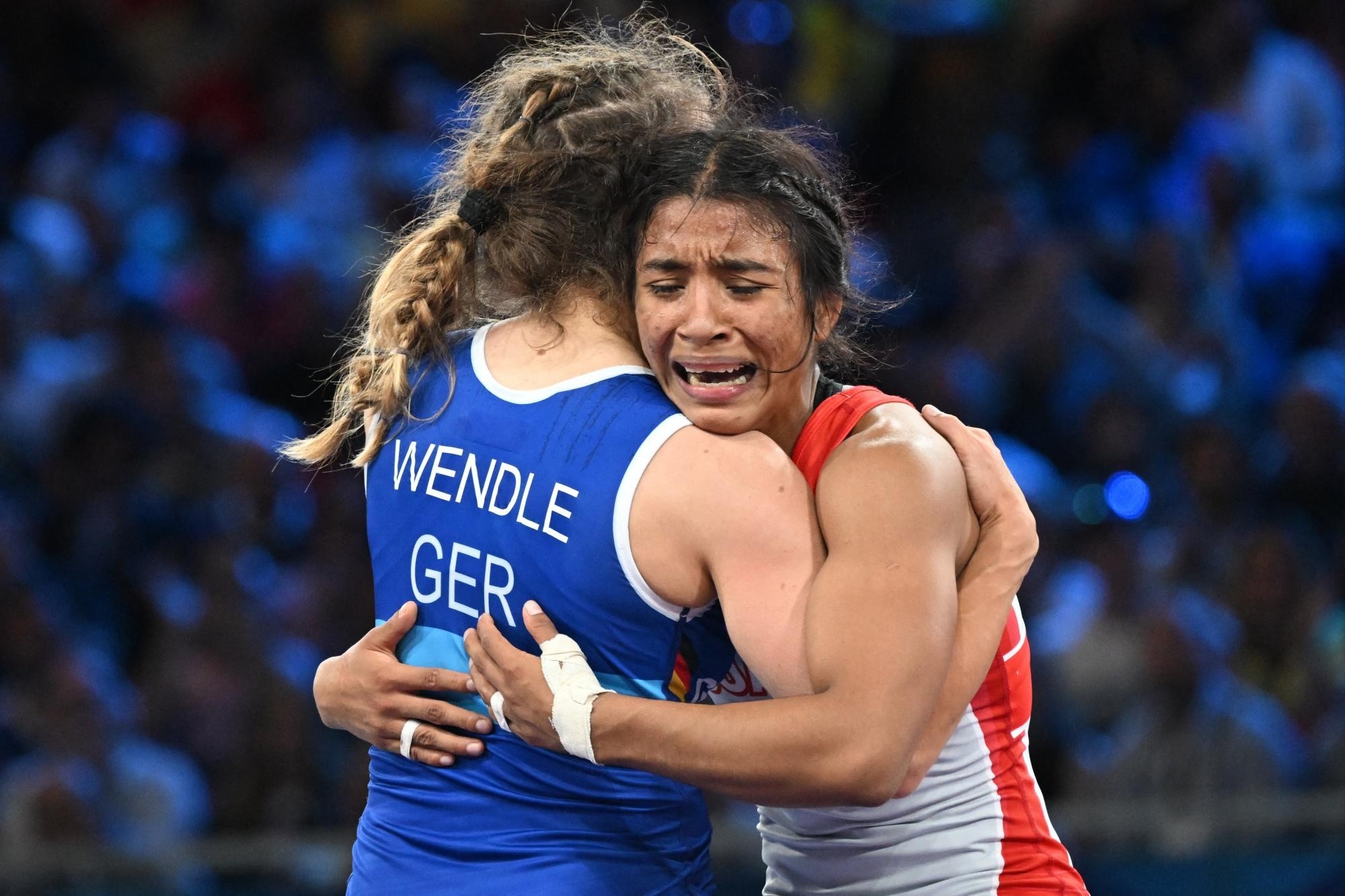 Lucía Yamileth Yepez Guzmán, de Ecuador, abraza a su oponente derrotada, Annika Wendle, de Alemania, después de su semifinal de lucha libre femenina de 53 kg en el Champ-de-Mars Arena durante los Juegos Olímpicos de París 2024. (PUNIT PARANJPE / AFP)