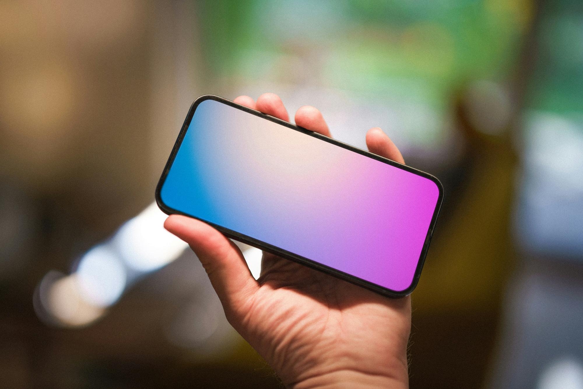 Imagen de una persona sosteniendo horizontalmente un teléfono. (Unsplash)