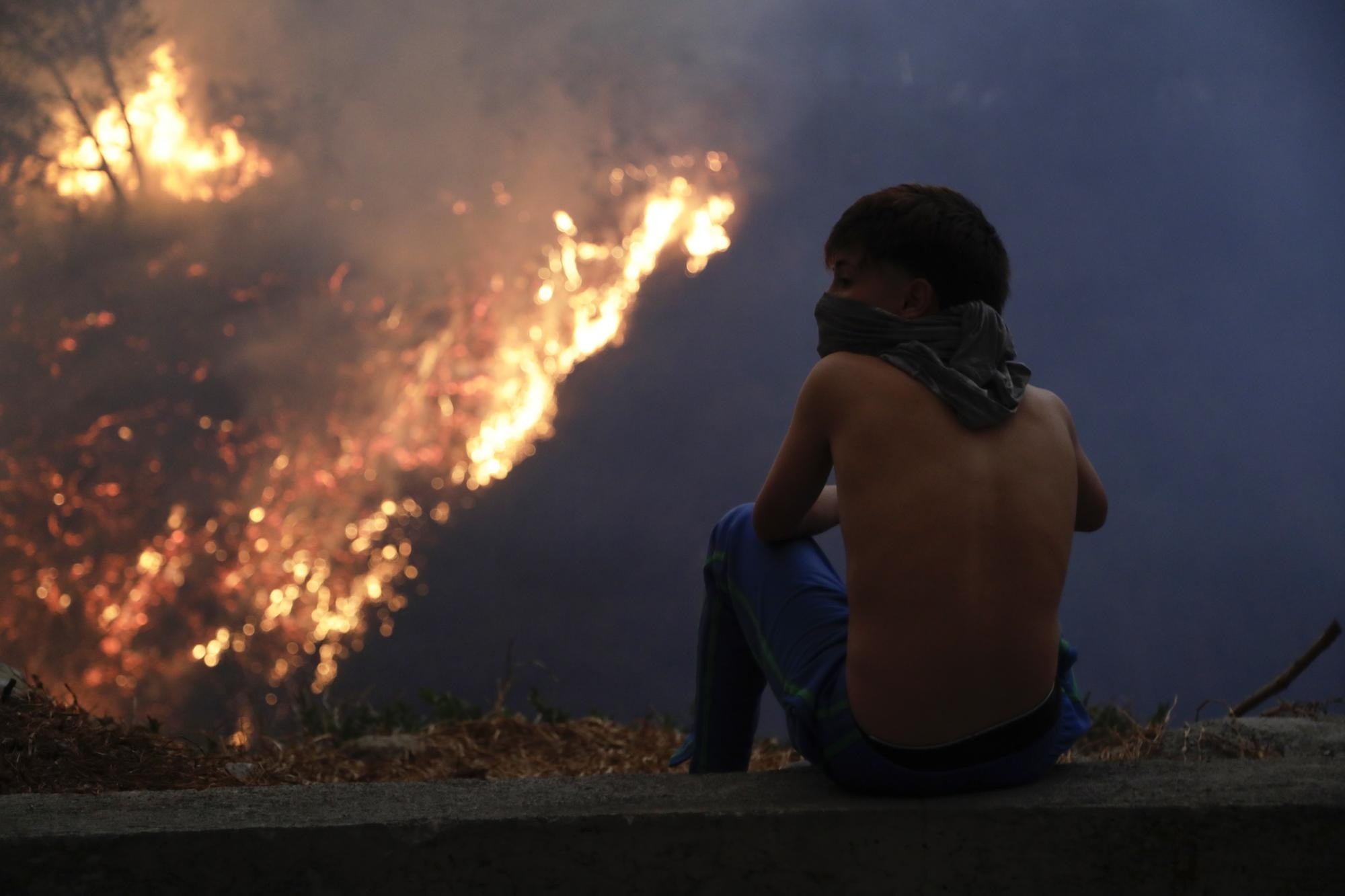 Un joven observa un incendio forestal este martes, en el sector de Guápulo en Quito. (EFE)