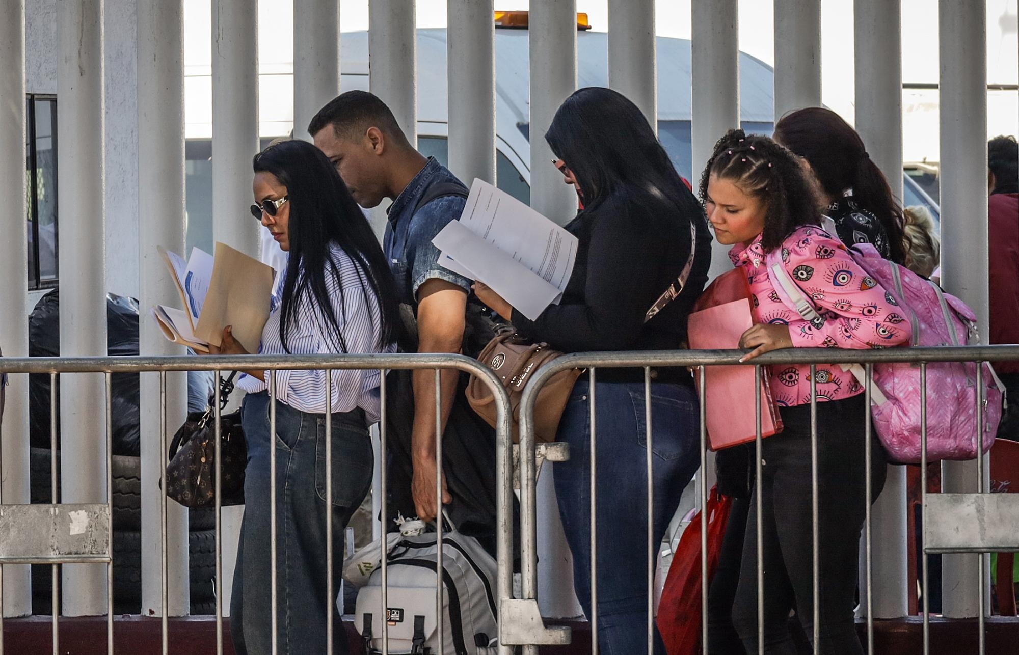 Migrantes hacen fila para solicitar papeles migratorios, este miércoles, en la ciudad de Tijuana, en el estado de Baja California (México). (EFE)