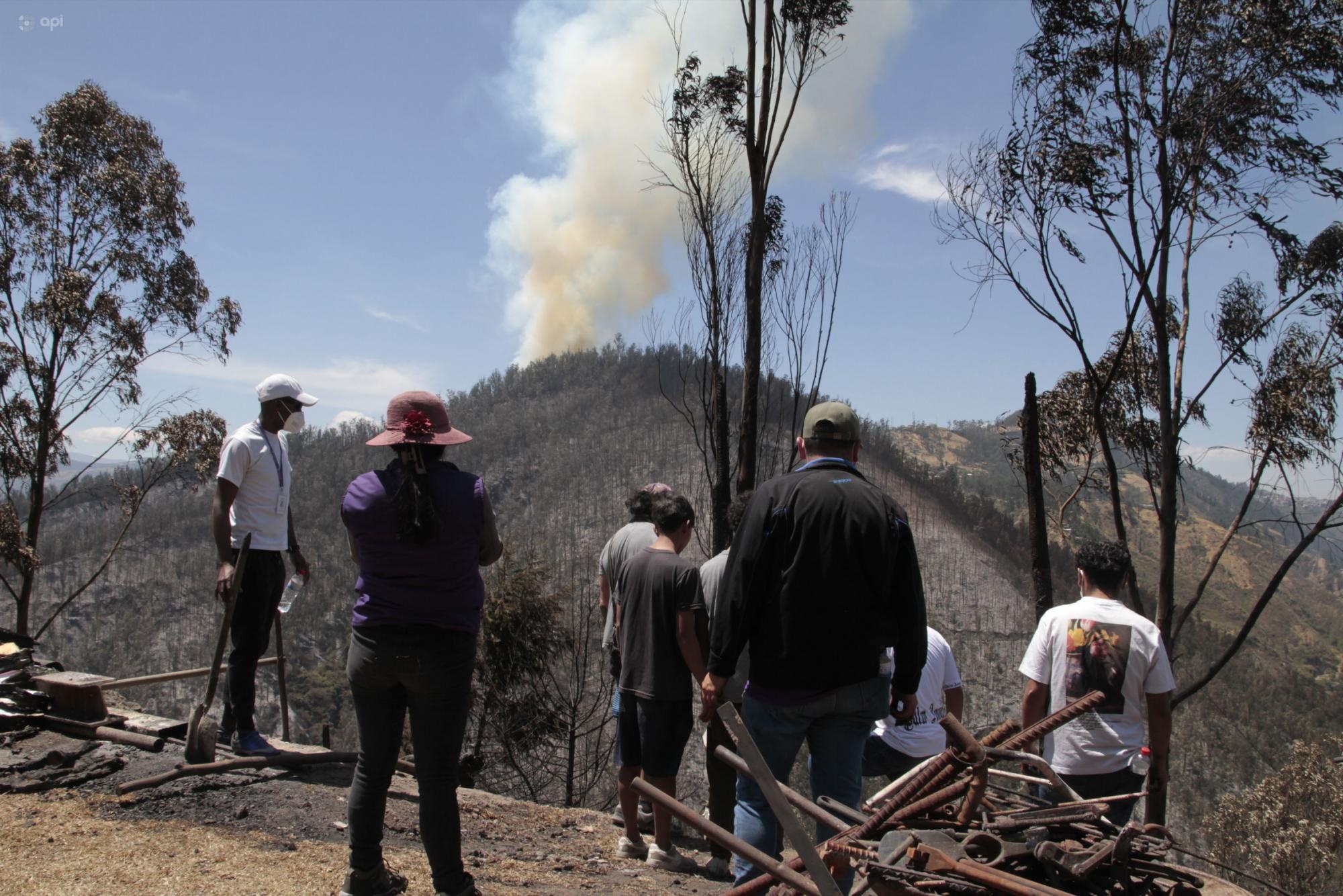 Ciudadanos miran un incendio en el cerro Auqui de Quito (API)