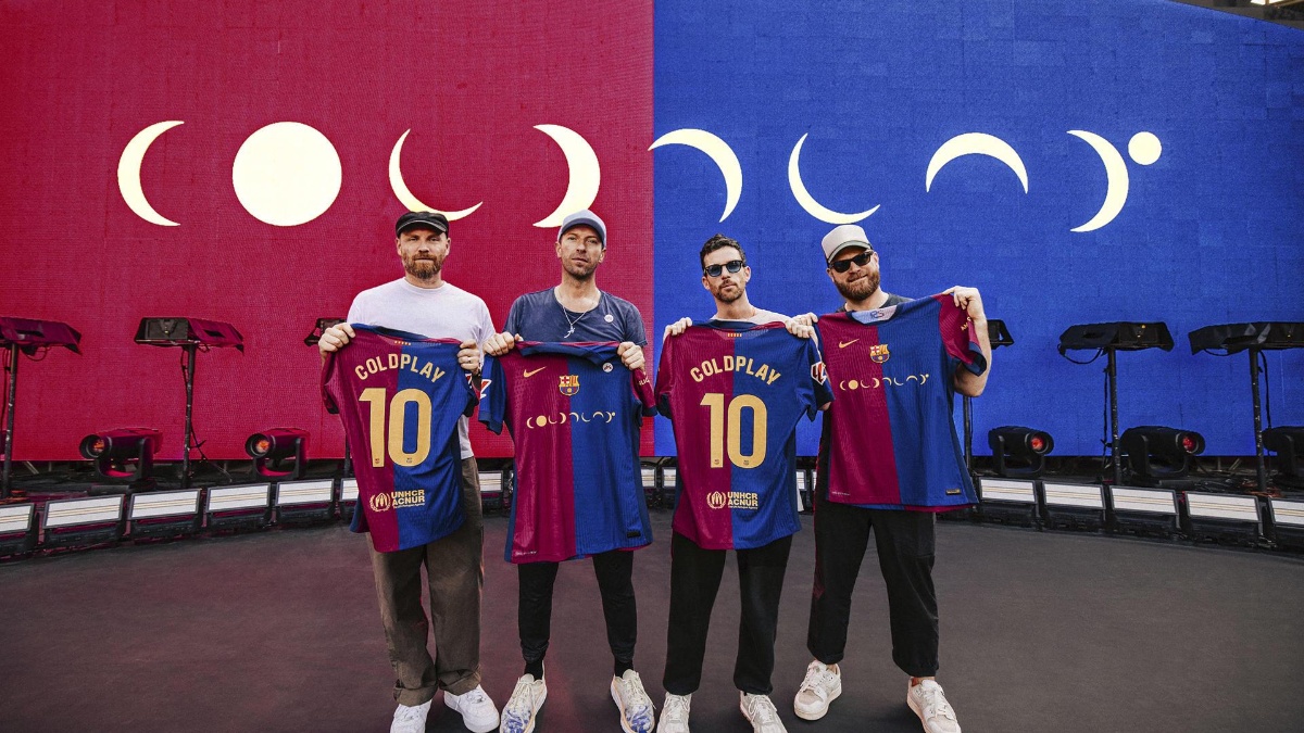 Los miembros de la banda Coldplay posan con las camisetas que el equipo masculino del Barcelona lucirá con el logotipo del grupo británico en el partido del próximo 26 de octubre en el Bernabéu ante el Real Madrid (EFE)