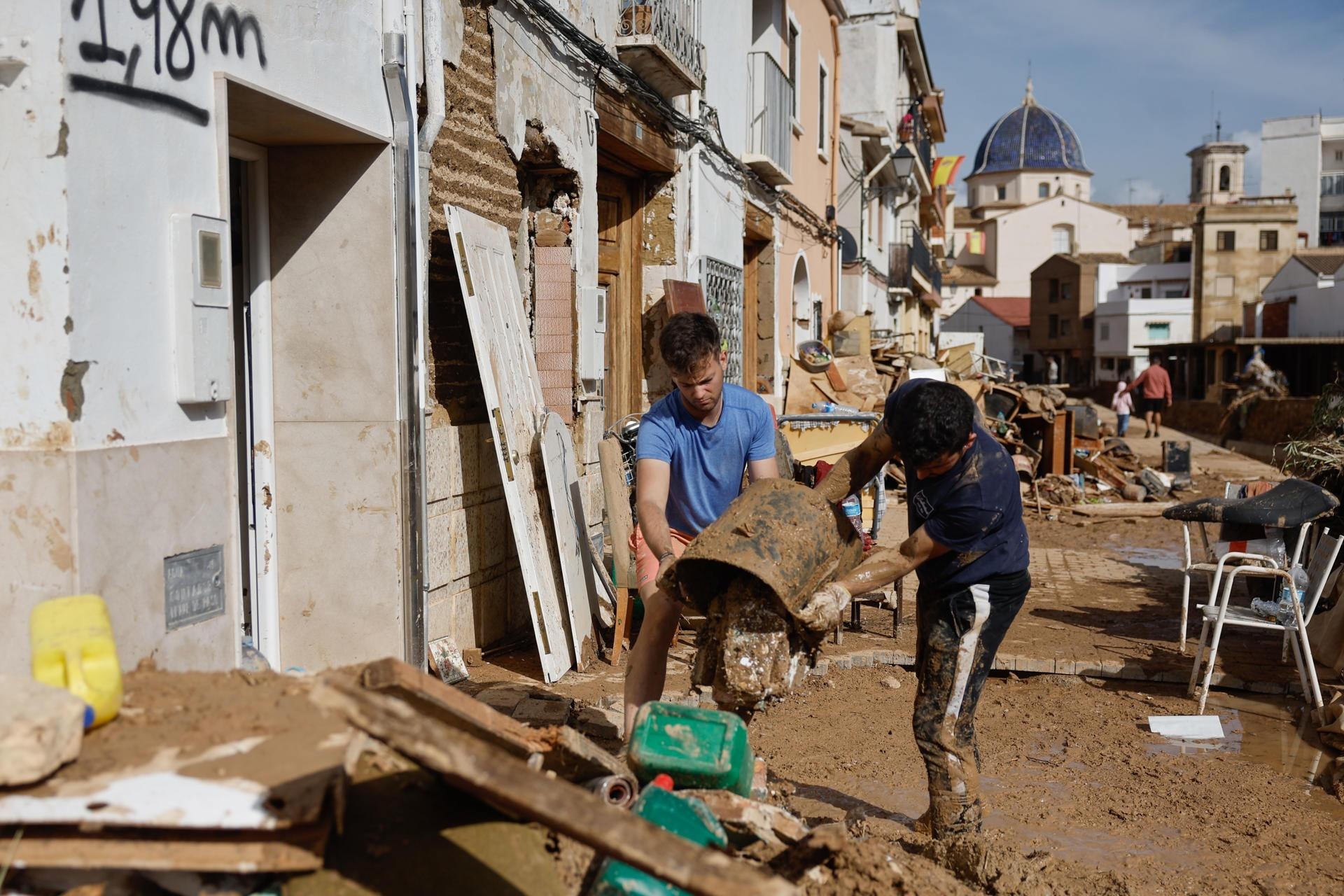 Vecinos de Chiva limpian sus hogares tras la DANA que ha asolado el sureste español y ha causado más de un centenar de muertos, este jueves. (EFE)