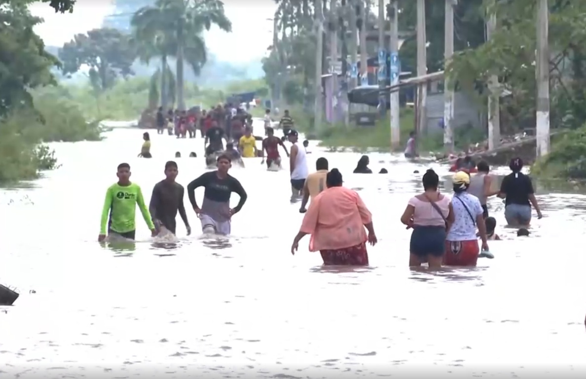 Imagen de personas inundadadas en una vía de Milagro. (Televistazo.)