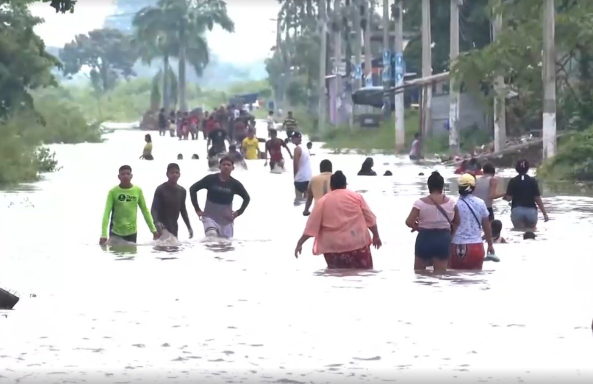 Imagen de personas inundadadas en una vía de Milagro. (Televistazo)