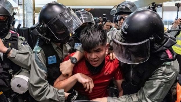 La policía arresta a un joven universitario durante las masivas protestas pro-democracia de 2019. (GETTY IMAGES)